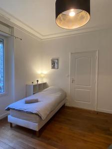 a bedroom with a bed and a lamp and a door at * L'appartement centre de Provins * ZEN LOC 4 in Provins