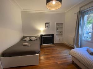 a bedroom with a bed and a television in it at * L'appartement centre de Provins * ZEN LOC 4 in Provins
