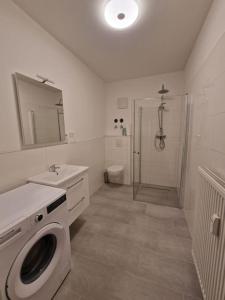 a bathroom with a washing machine and a sink at Cozy apartment in the center of Berlin 33 in Berlin