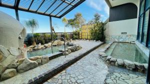 a swimming pool with rocks around a building at Route Inn Grantia Aoshima Taiyokaku in Miyazaki