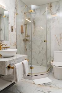 a bathroom with a glass shower and a sink at St Palace Hotel in Vilnius