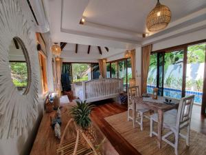sala de estar con mesa y sofá en Soul Villas by The Beach - Phuket, en Panwa Beach