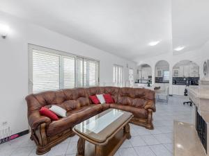 a living room with a brown leather couch and a table at Beautiful Holiday Home in Neoric in Neorić