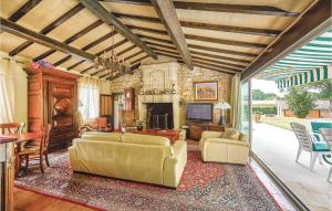 a living room with a couch and a table and a television at Cozy Home In Saint-vivien-de-medoc With Wifi in Saint-Vivien-de-Médoc