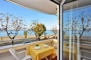 balcón con mesa y vistas a la playa en Katerina Rooms for Rent en La Canea