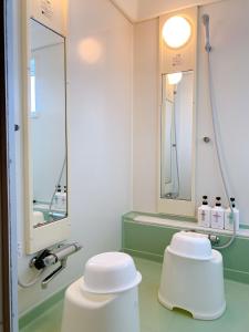 a bathroom with two white stools and a mirror at oyado nanahoshi - Vacation STAY 59285v in Hokuto