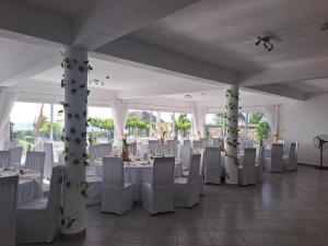 a banquet hall with white tables and white chairs at Aux 2 Métis in Toliara