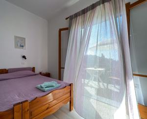 ein Schlafzimmer mit einem Bett und einem großen Fenster in der Unterkunft Anemone in Pelekas