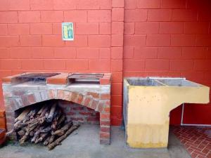 a brick wall with a table and a pile of wood at Jasper House en Ciudad Real Santa Ana in Santa Ana
