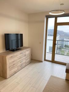 una sala de estar con TV de pantalla plana en una cómoda de madera en Central apartment, en Vilna