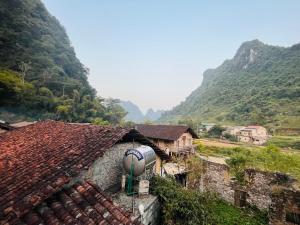 a group of buildings with mountains in the background at Homestay Bản Giốc- Tay's Traditional Village in Cao Bằng