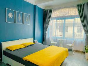 a bedroom with a bed and a blue wall at La Casa Homestay - 11B Anh Đào, Bãi Cháy in Ha Long