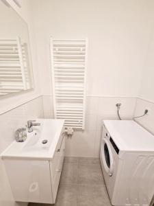 a white bathroom with a washing machine and a sink at Luxurious studio in the heart of Berlin 21 in Berlin