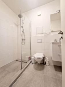 a white bathroom with a toilet and a shower at Luxurious studio in the heart of Berlin 21 in Berlin