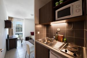 a kitchen with a sink and a microwave at Garden & City Toulon in Toulon