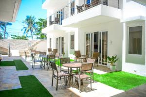 patio ze stołami, krzesłami i trawą w obiekcie Aira Boracay Hotel w mieście Boracay