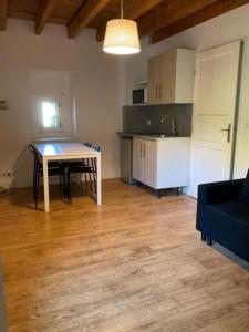 a living room with a table and a kitchen at Ravissant appartement dans cadre verdoyant in Marchampt