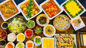 a table topped with bowls of different types of food at Route Inn Grantia Aoshima Taiyokaku in Miyazaki