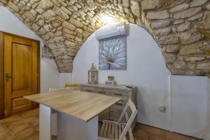 una cucina con tavolo e parete in pietra di La casetta di Pietra a Sassari