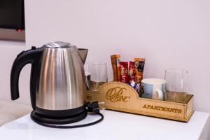 a tea kettle on a table with a tray of drinks at Princ Apartment in Niš