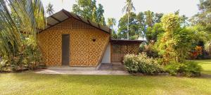 una pequeña casa con una puerta en un patio en Bat Tree Cottages, en Agoho