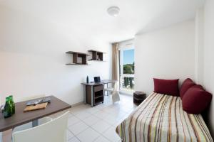 una camera con letto, scrivania e tavolo di Garden & City Toulon a Tolone