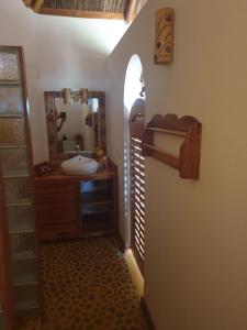 La salle de bains est pourvue d'un lavabo et d'un miroir. dans l'établissement villa nosy détente, à Nosy Be