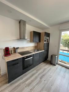 a kitchen with a sink and a stove top oven at Jed YourHostHelper in Ouistreham