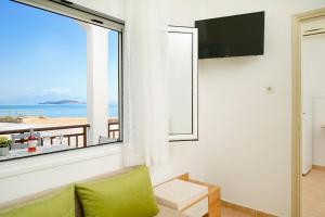 a room with a window with a view of the beach at Evelyn Studios in Olympiada