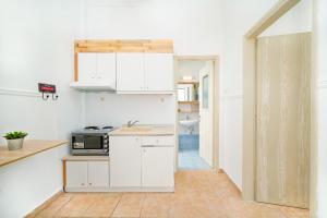 a kitchen with white cabinets and a microwave at Evelyn Studios in Olympiada