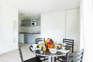 a dining room table with a bowl of fruit on it at Garden & City Lyon - Marcy in Marcy-lʼÉtoile