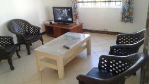 a living room with a table and chairs and a tv at DINO 4 in Trou aux Biches
