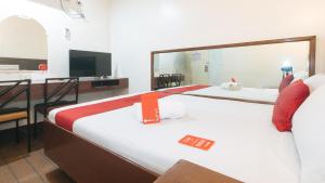 Cette chambre comprend deux lits et une télévision. dans l'établissement RedDoorz @ Riches Holiday Hotel Avenida, à Manille