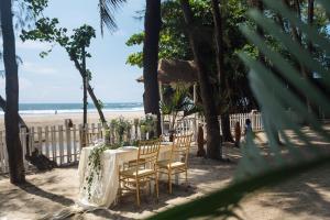 a table and chairs on a beach with the ocean at Larisa Beach Resort in Morjim