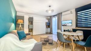 uma sala de estar com um sofá e uma mesa em HOMEY HELSINKI - Hyper centre - Proche Genève - Terrasse privée - Wifi & Netflix em Annemasse