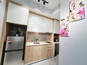 a kitchen with white cabinets and a refrigerator at LovelySuite#RelaxChill#Netflix#PrivateBathtub#FreeParking#PoolView#ImperioResidence#LuxuryCondo in Melaka