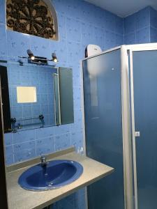 a blue bathroom with a sink and a mirror at Nguyen Shack - Sai Gon in Ho Chi Minh City