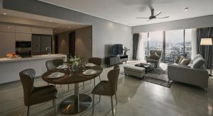 cocina y sala de estar con mesa y sillas en TRILLION SUITES by SLG en Kuala Lumpur