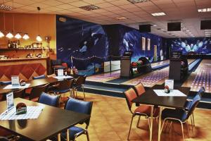 a dining room with tables and chairs and a bowling alley at Apartmán Adam Deštné v Orlických horách in Deštné v Orlických horách