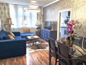 a living room with a blue couch and a table at Ferienwohnung Royal im Tilly Boardinghouse in Hannoversch Münden +21 photos