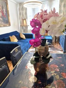 a living room with a vase with flowers on a table at Ferienwohnung Royal im Tilly Boardinghouse in Hannoversch Münden