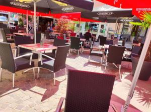 a restaurant with tables and chairs and umbrellas at F3 centre d hericourt Fibre et Netfix in Héricourt