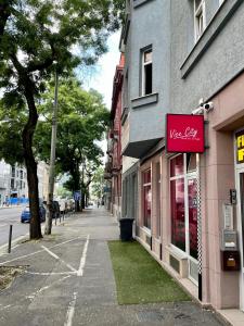 een gebouw met een roze bord aan de straatkant bij 1 st may plaza de luxe in Bratislava