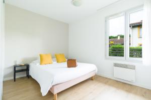 a white bedroom with a bed and a window at Garden & City Lyon - Lissieu in Lissieu