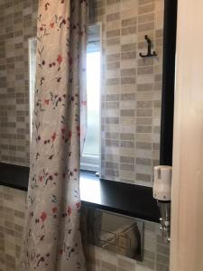 uma casa de banho com uma cortina de chuveiro e uma janela em Studio-4 for professionals em Staines
