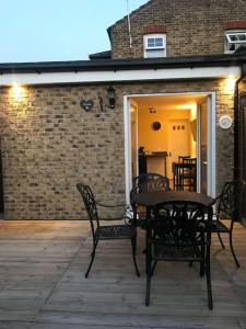 a patio with a table and chairs on a deck at Studio-4 for professionals in Staines