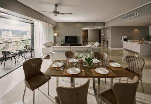 a dining room and living room with a table and chairs at TRILLION SUITES by SLG in Kuala Lumpur