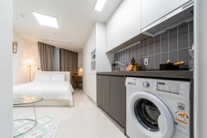 pokój hotelowy z łóżkiem i pralką w obiekcie Urbanstay Busan Cityhall w Pusanie