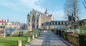 a large building with a statue in front of it at Au Jardin Saint Laurent in Eu