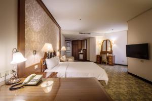 una camera d'albergo con letto e scrivania con telefono di Guide Hotel Zhongli Zhongzheng a Zhongli